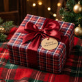 Red and blue plaid Christmas gift wrap with a red satin bow and Merry Christmas tag, by Wrapped Studios.