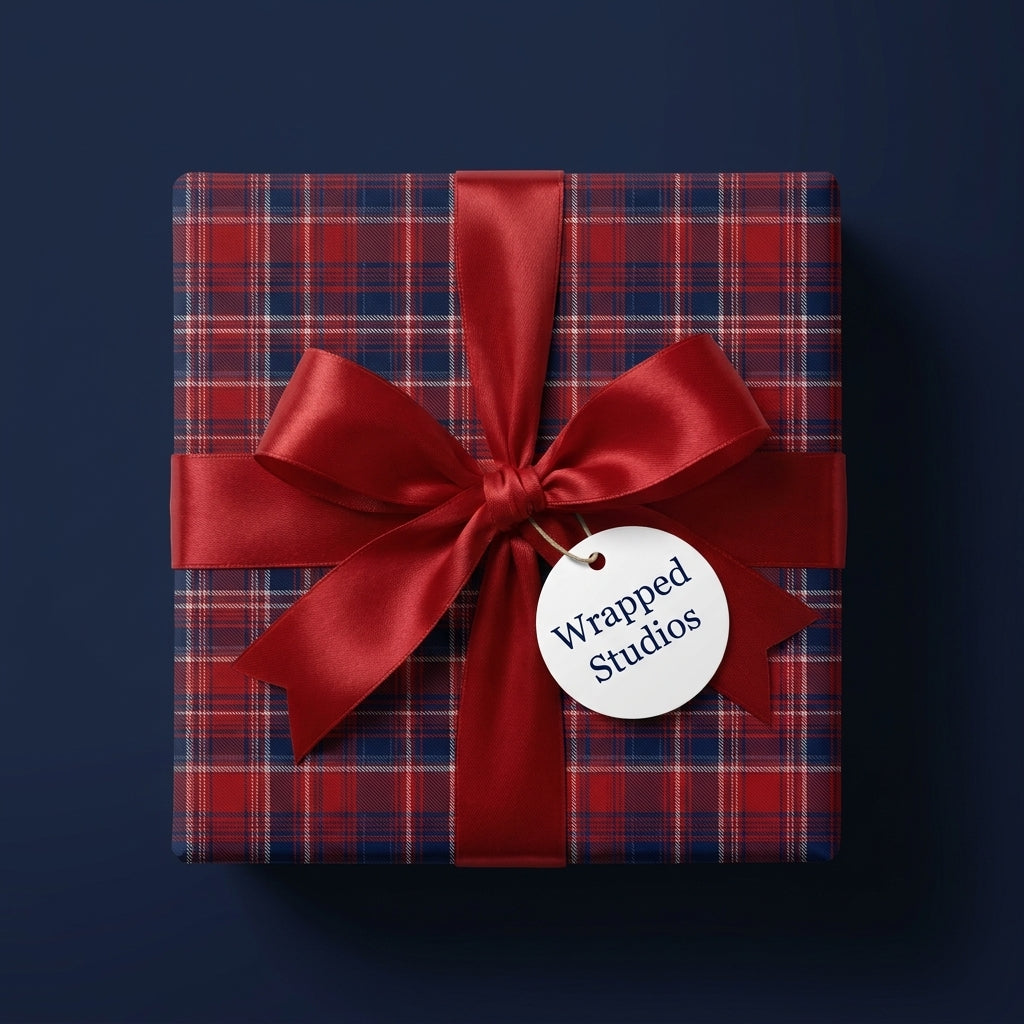 Luxury red plaid Christmas wrapping paper with a satin bow and Wrapped Studios tag.