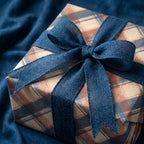 Rustic navy and brown plaid wrapping paper with a blue burlap ribbon by Wrapped Studios.