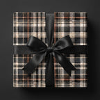 Black plaid wrapping paper with a satin ribbon bow on a luxury gift box by Wrapped Studios.