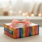 Wrapped gift with colorful rainbow stripe wrapping paper and a delicate peach ribbon bow.