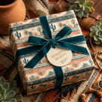 Southwestern desert cactus wrapping paper with a teal velvet ribbon and Wrapped Studios gift tag.