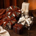 Moody gothic skull and floral wrapping paper with rust velvet bows on gift boxes by Wrapped Studios.