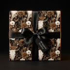 Moody gothic skull and floral wrapping paper with black satin bow on luxury gift box by Wrapped Studios.