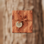 Rustic woodgrain wrapping paper with a copper ribbon and circular tag, perfect for neutral gift wrap.