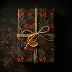 Rustic botanical Christmas wrapping paper with pinecones, twine, and dried orange by Wrapped Studios.