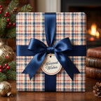 Cozy plaid Christmas wrapping paper with a navy satin bow and holiday tag by Wrapped Studios.