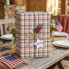 Patriotic red, white, and blue plaid wrapping paper on a rustic gift box with twine by Wrapped Studios.