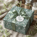 Sage green botanical floral gift wrap with elegant satin ribbon and gift tag by Wrapped Studios.