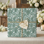 Sage green botanical floral wrapping paper on a wedding gift box with gold twine by Wrapped Studios.