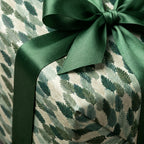 Luxury botanical leaf wrapping paper with a green satin ribbon bow by Wrapped Studios.