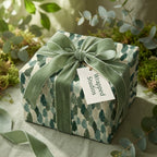 Botanical Christmas wrapping paper by Wrapped Studios, tied with a luxury sage green velvet ribbon.