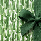 Green watercolor cactus wrapping paper with a green herringbone bow, modern birthday gift wrap by Wrapped Studios.