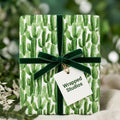 Watercolor cactus wrapping paper by Wrapped Studios tied with a dark green velvet bow.