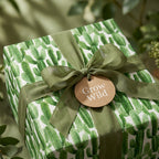Cactus wrapping paper with sage green ribbon and Grow Wild tag by Wrapped Studios.