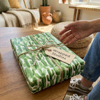 Green cactus wrapping paper by Wrapped Studios on a gift box tied with rustic twine in a boho home.