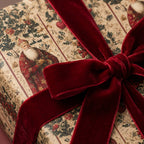 Christmas gift wrapped in vintage Santa floral wrapping paper and tied with a red velvet ribbon bow.