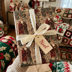 Christmas gift wrapped in Wrapped Studios' vintage Santa Claus paper with cream ribbon and "Noel" tag.