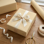 Beige wrapping paper roll & gift box, tied with cream satin ribbon. Elegant neutral solid color gift wrap for weddings or birthdays.