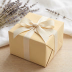 Beige gift box wrapped in solid color wrapping paper with ribbon and bow for birthday, wedding, or party.