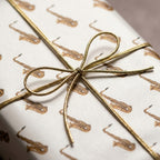 Vintage saxophone wrapping paper with gold bow. Elegant music gift wrap by Wrapped Studios.