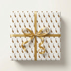Saxophone wrapping paper with a gold satin ribbon bow on a square gift box, by Wrapped Studios.