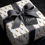 Gold saxophone wrapping paper with a grey ribbon bow and Cheers tag by Wrapped Studios.