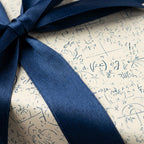 Math formulas and science wrapping paper with a navy blue satin ribbon bow by Wrapped Studios.