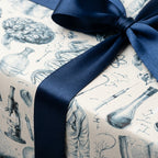 Vintage science wrapping paper with medical drawings and navy satin bow, by Wrapped Studios.