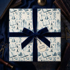 Vintage doctor wrapping paper with medical sketches and a navy velvet bow by Wrapped Studios.