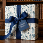 Science wrapping paper with vintage medical illustrations, navy ribbon, and Wrapped Studios gift tag.