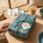 Sea turtle wrapping paper by Wrapped Studios tied with teal twine on a coastal table.