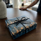 Seattle skyline wrapping paper by Wrapped Studios on a gift box with a black ribbon.