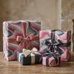 Elegant gifts wrapped in modern wave pattern paper with velvet ribbons. Luxury gift wrap from Wrapped Studios.