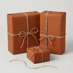 Minimalist rustic gift wrap: terracotta paper & twine on present boxes for birthdays, holidays, or special occasions.