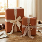 Two gifts wrapped in solid brown paper with lace and raw-edge ribbon on a rustic wood surface.