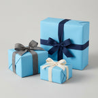 Light blue gift-wrapped presents with navy, gray, and cream ribbon bows.