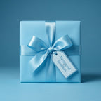 Light blue wrapping paper mockup on a square gift box with satin ribbon and gift tag.