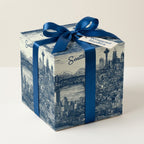 Gift wrapped in blue Seattle-themed wrapping paper with a satin ribbon bow.