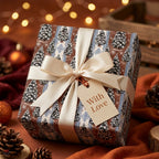 Vintage Christmas wrapping paper with tree print, cream satin bow, and gift tag by Wrapped Studios.
