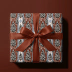 Vintage Christmas wrapping paper with snowy pine trees and a rust satin bow by Wrapped Studios.