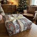 Rustic Christmas wrapping paper with vintage tree pattern and cream ribbon by Wrapped Studios.