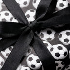 Soccer ball birthday wrapping paper with a black satin bow by Wrapped Studios.