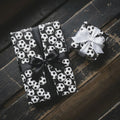 Soccer wrapping paper on sports gift boxes with black and white satin bows by Wrapped Studios.
