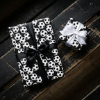Soccer wrapping paper on sports gift boxes with black and white satin bows by Wrapped Studios.