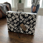Soccer wrapping paper featuring black and white soccer balls on a gift box, by Wrapped Studios.