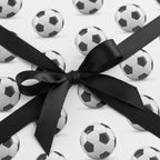 Gift wrapped in soccer ball paper with a black satin ribbon from Wrapped Studios.