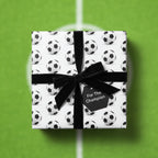 Soccer-themed gift wrap featuring a black velvet ribbon and "For the Champion" tag.