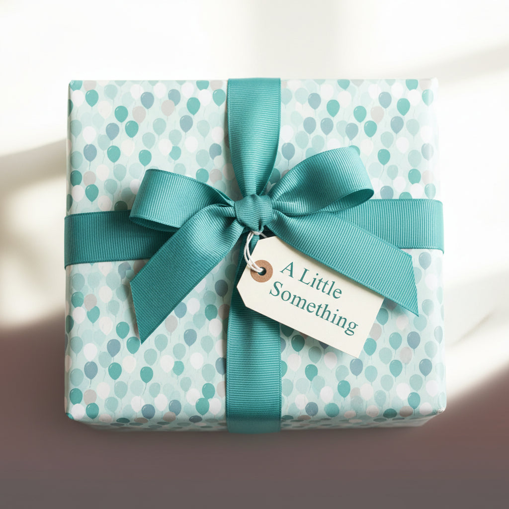 Wrapped gift with light blue balloon pattern paper, teal ribbon, and "A Little Something" tag.