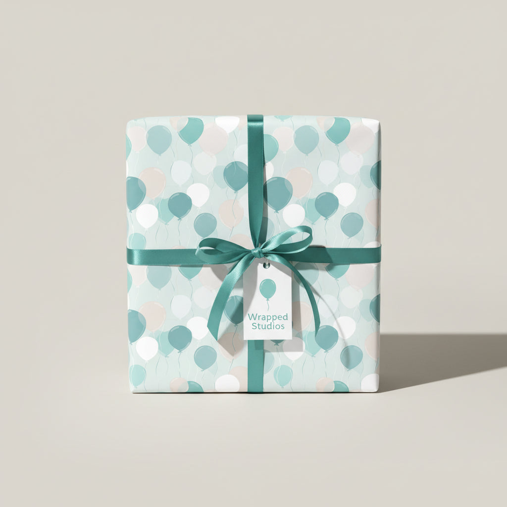 Square gift wrapped in balloon-patterned birthday wrapping paper with a teal ribbon.